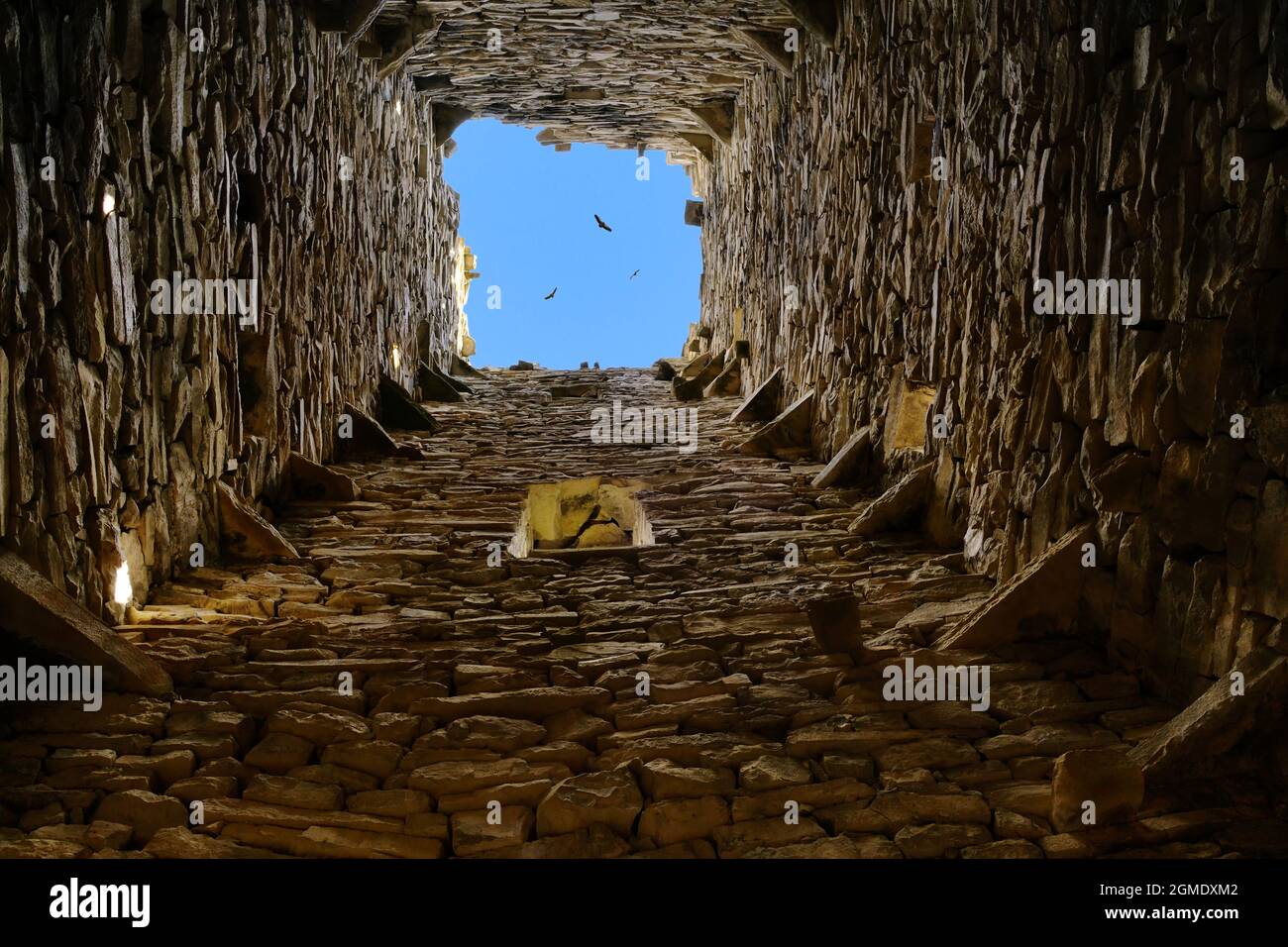 Inside view on the blue sky and flock of eagles in medieval ruins building of the Harcaroy Battle Tower. Kharkaroi village, Vedensky district, Chechen Stock Photo