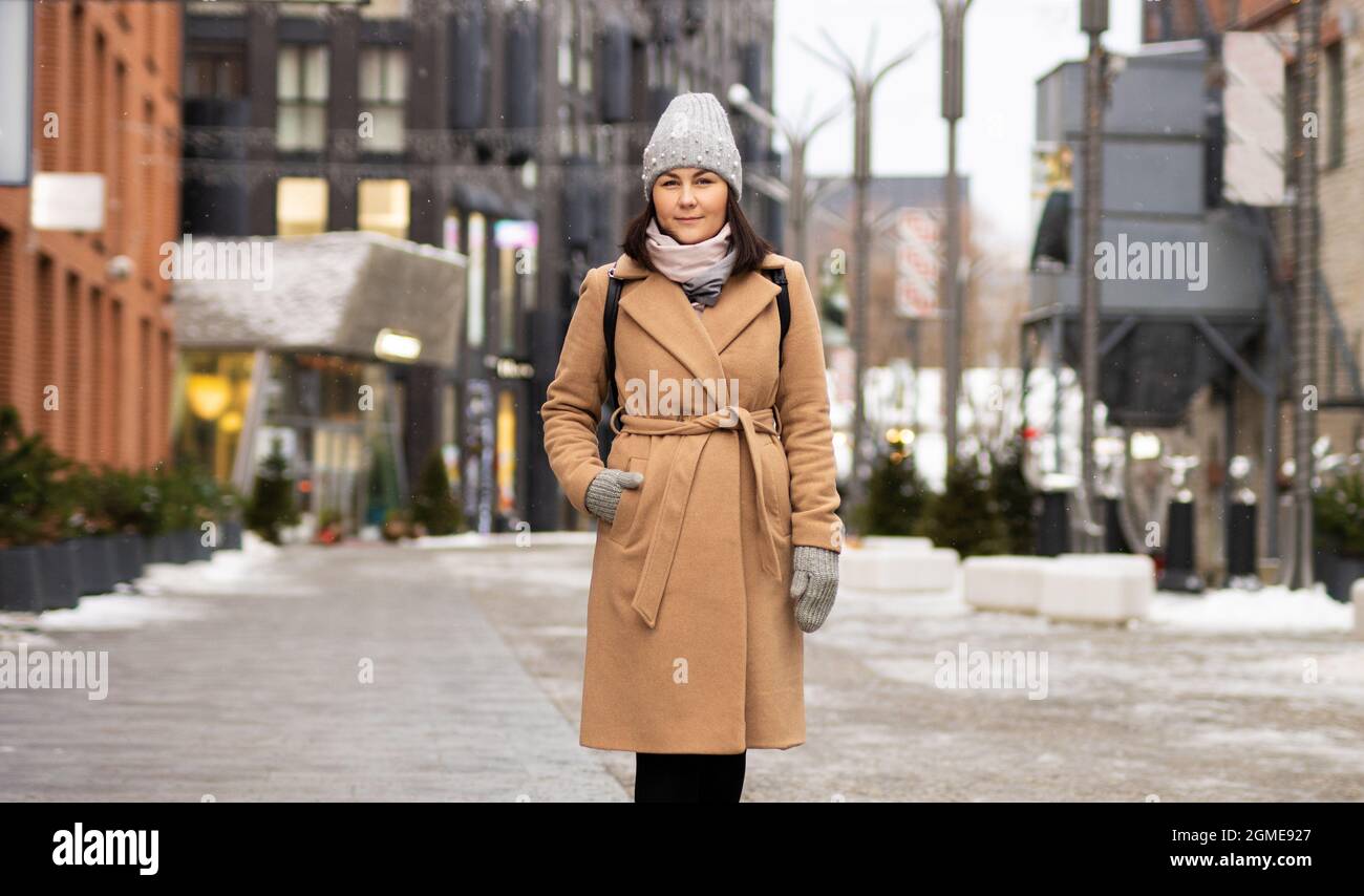 Outdoor portrait of happy woman in coat walking down the street Stock ...