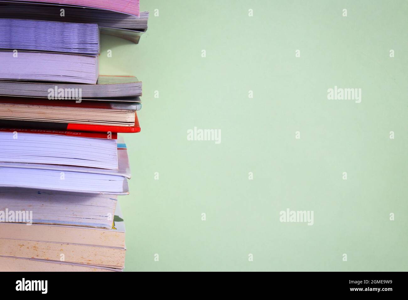 Stack of books on green background with copy space for text Stock Photo