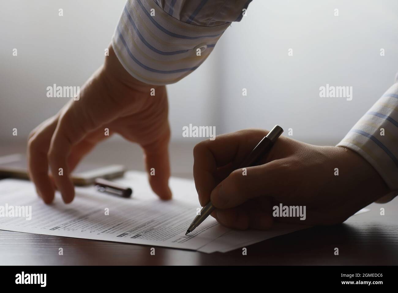 Business meeting. A man signs a contract. Male hand with pen makes ...