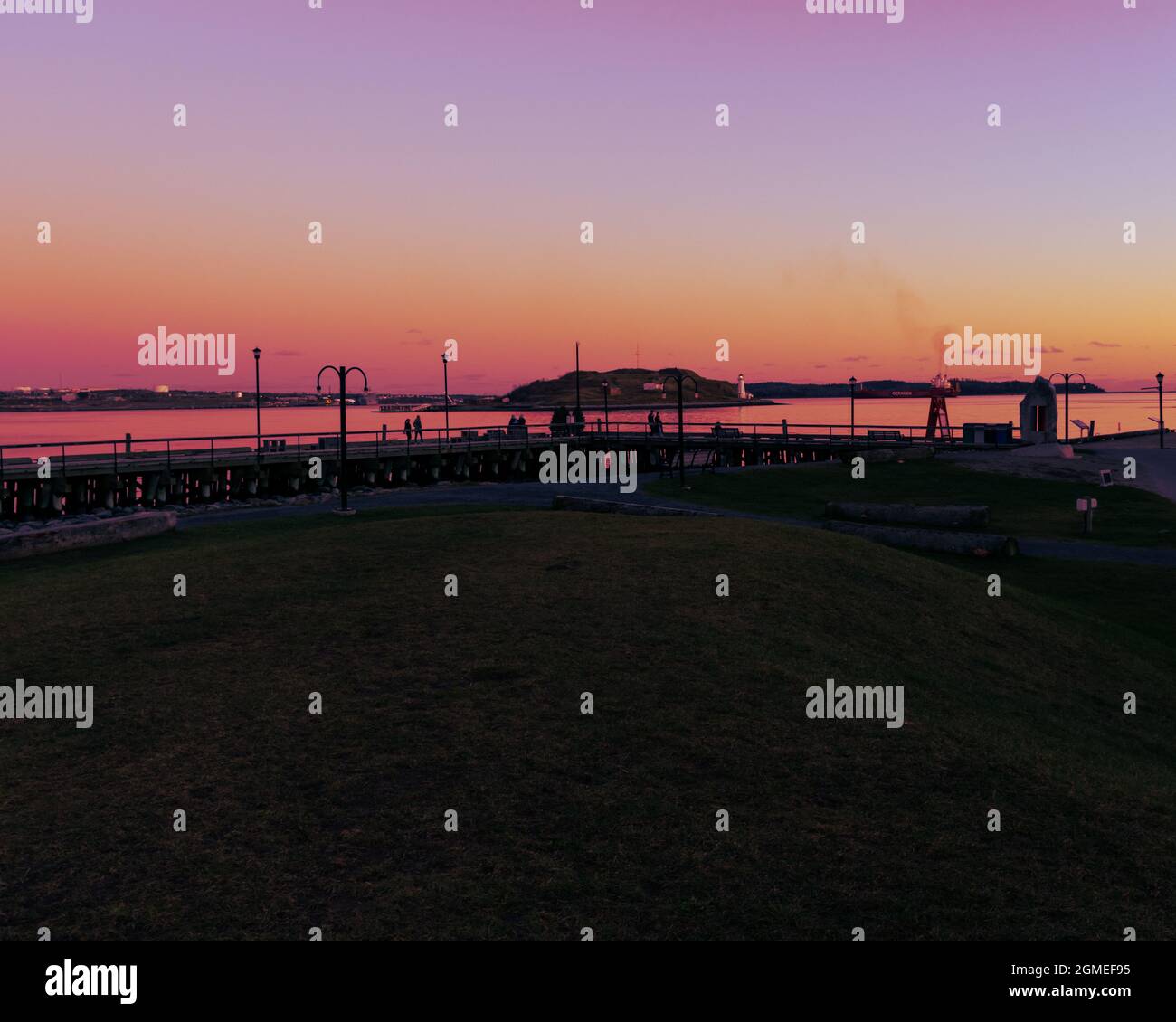 halifax harbour front boardwalk in summer during sunset with georges island in the background Stock Photo