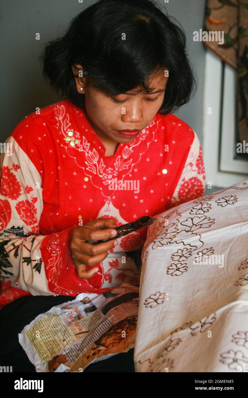 A woman is demonstrating how to make batik at the Tegal batik exhibition. Stock Photo