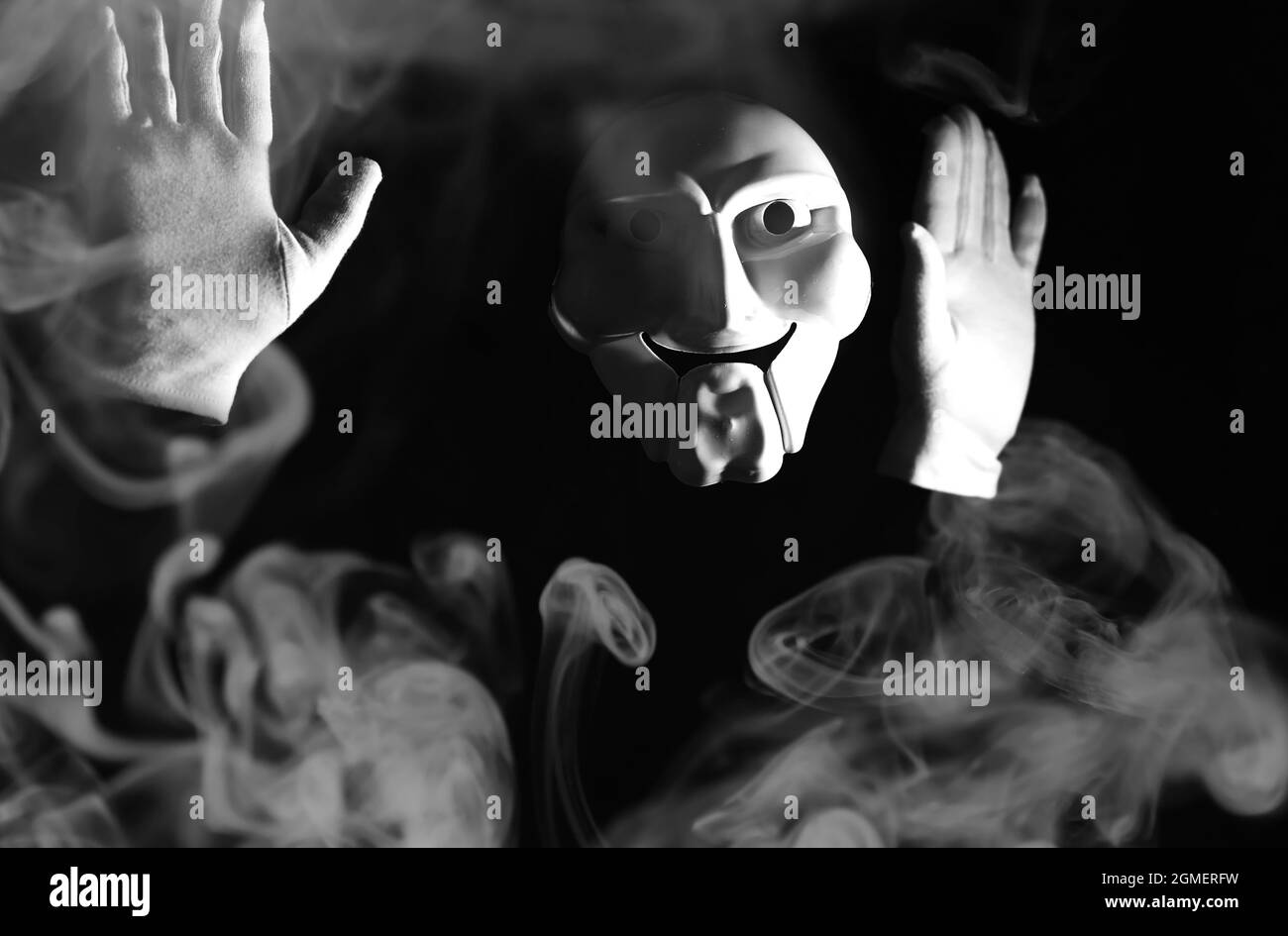 White scary mask on a black background with whites hands Stock Photo