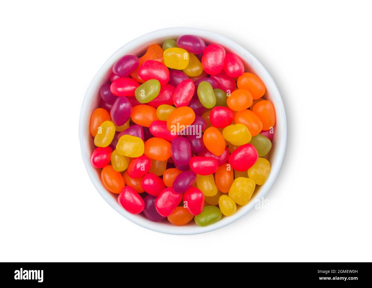 Various jelly beans sweet gummy candies in ceramic plate on white background. Top view Stock Photo