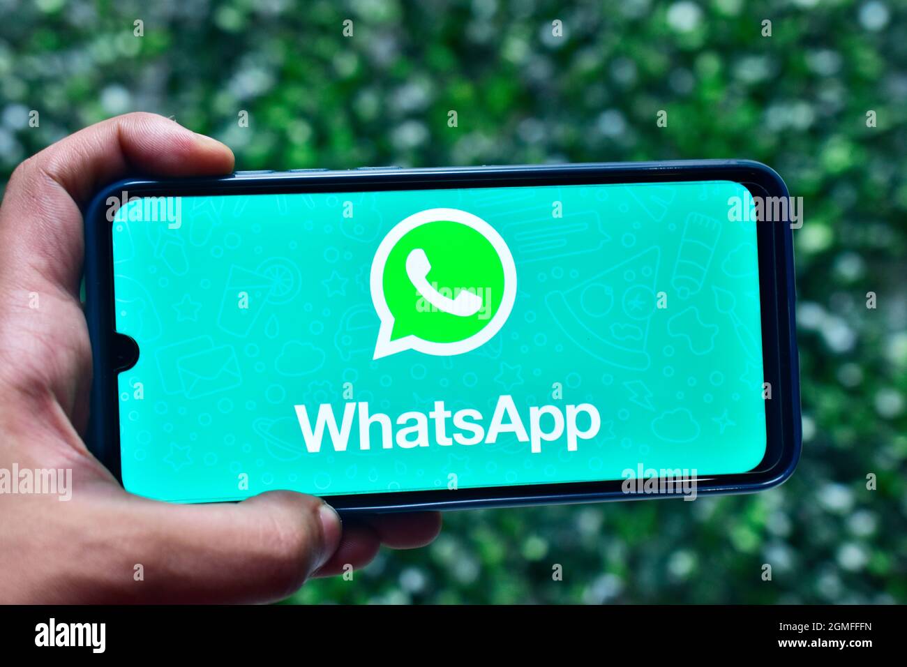 New Delhi, India - September 08, 2019: Hand holding smartphone with WhatsApp logo on screen Stock Photo