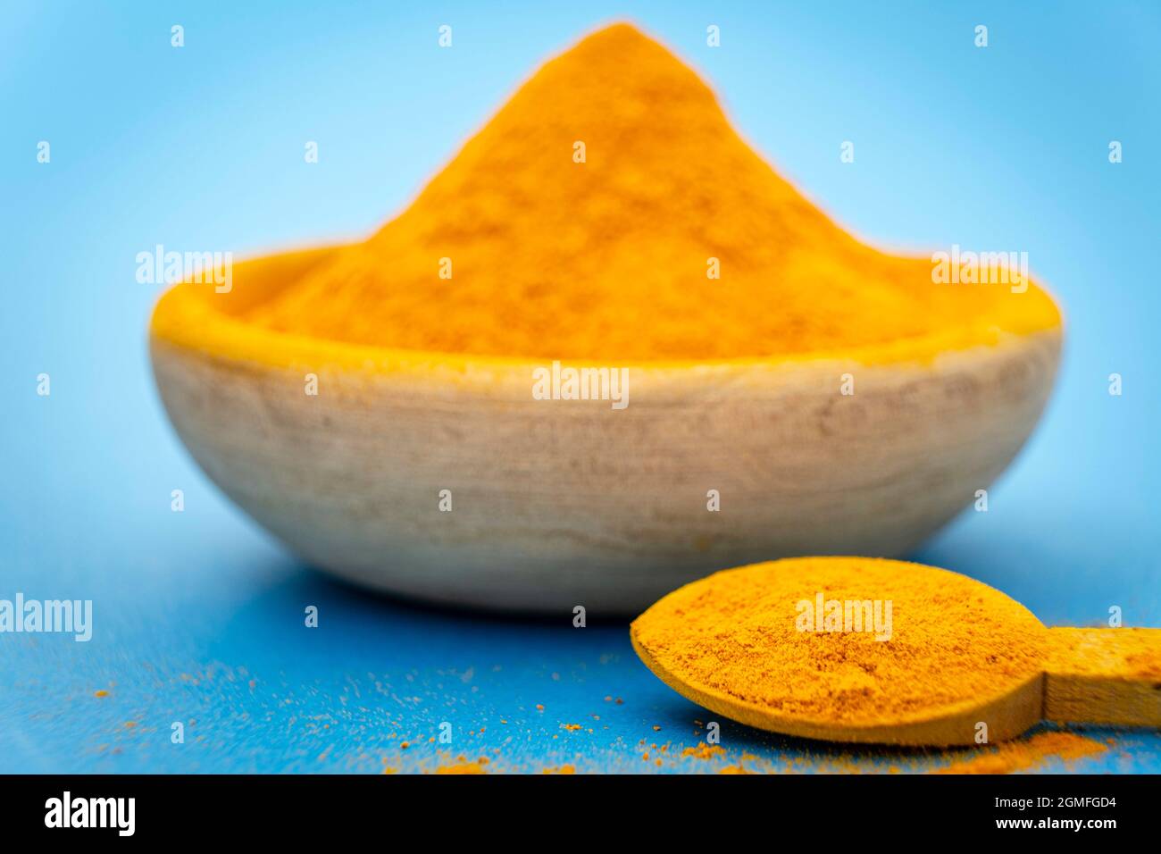 ground turmeric on blue background Stock Photo - Alamy