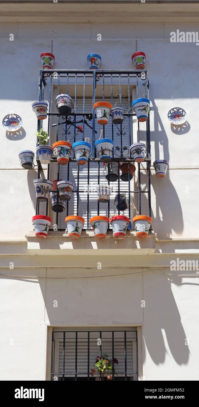 colorful pots with plants hanging from the window railings, Malaga, Spain Stock Photo