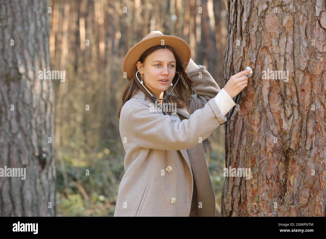 young woman is listening and care of a tree with stethoscope,dream  job,female are a doctor,checking healthy green trees in park,love  nature,protect en Stock Photo - Alamy