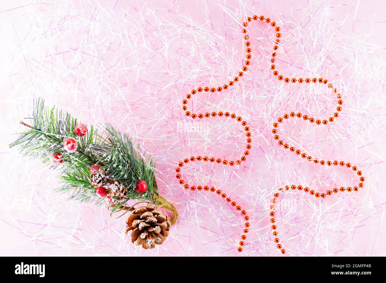 Symbol Christmas and Happy New Year figure christmas tree with red beads on tinsel. Christmas beads on pink tinsel. Holiday concept. Top view Stock Photo