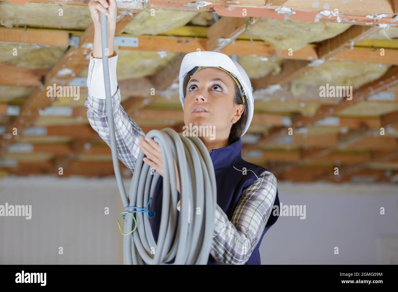 female electrician fitting air conditions pipes Stock Photo