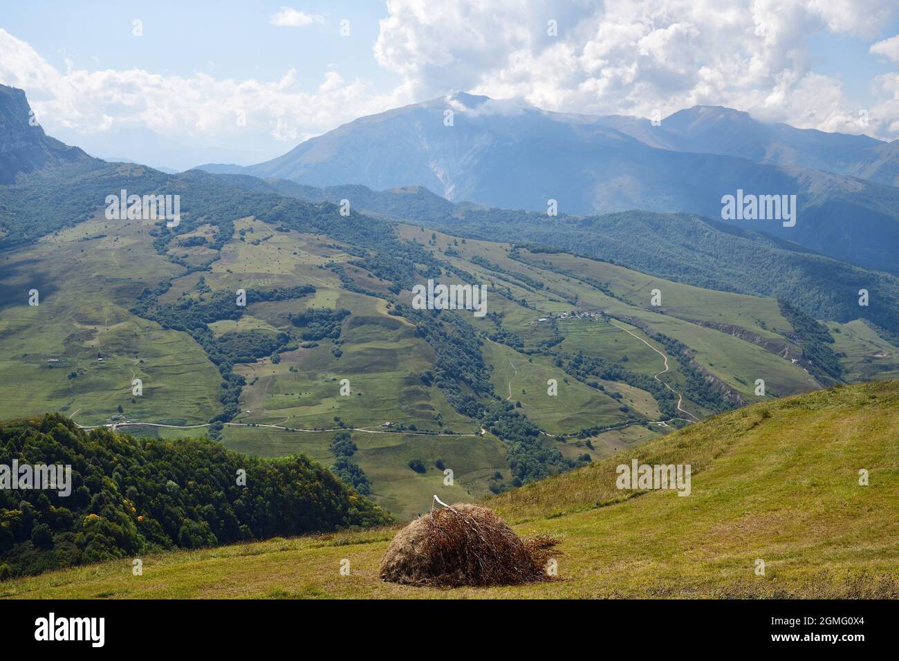 Ф stack of hay. Caucasus alpine meadow and mountains landscape in Chechnya, Russia. Vedeno district of the Chechen Republic Stock Photo