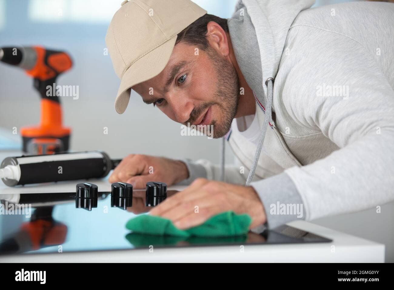 young handyman fixing a kitchen extractor with a screwdriver Stock ...