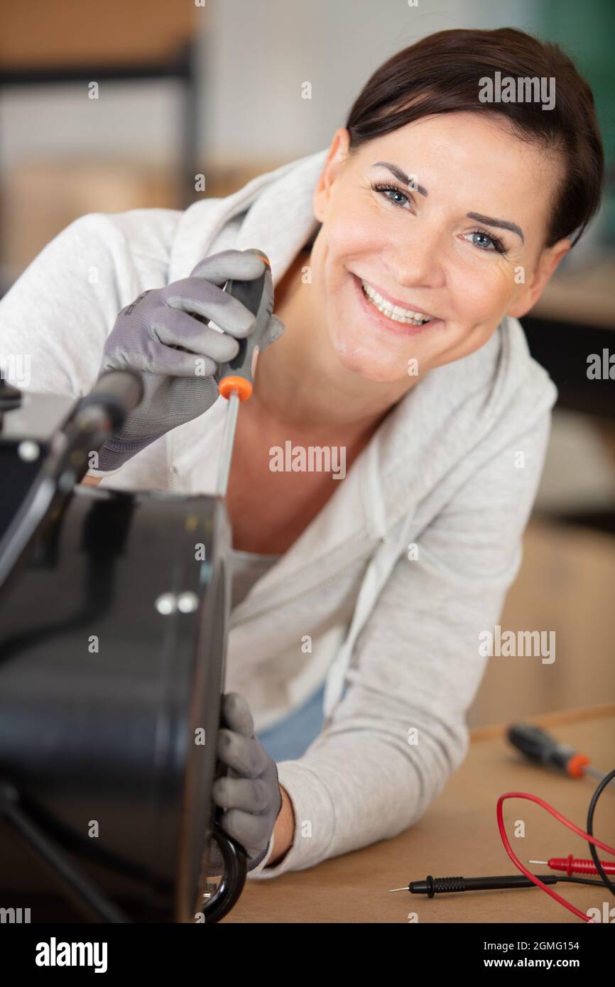 cheerful female engineer using a screwdriver Stock Photo - Alamy