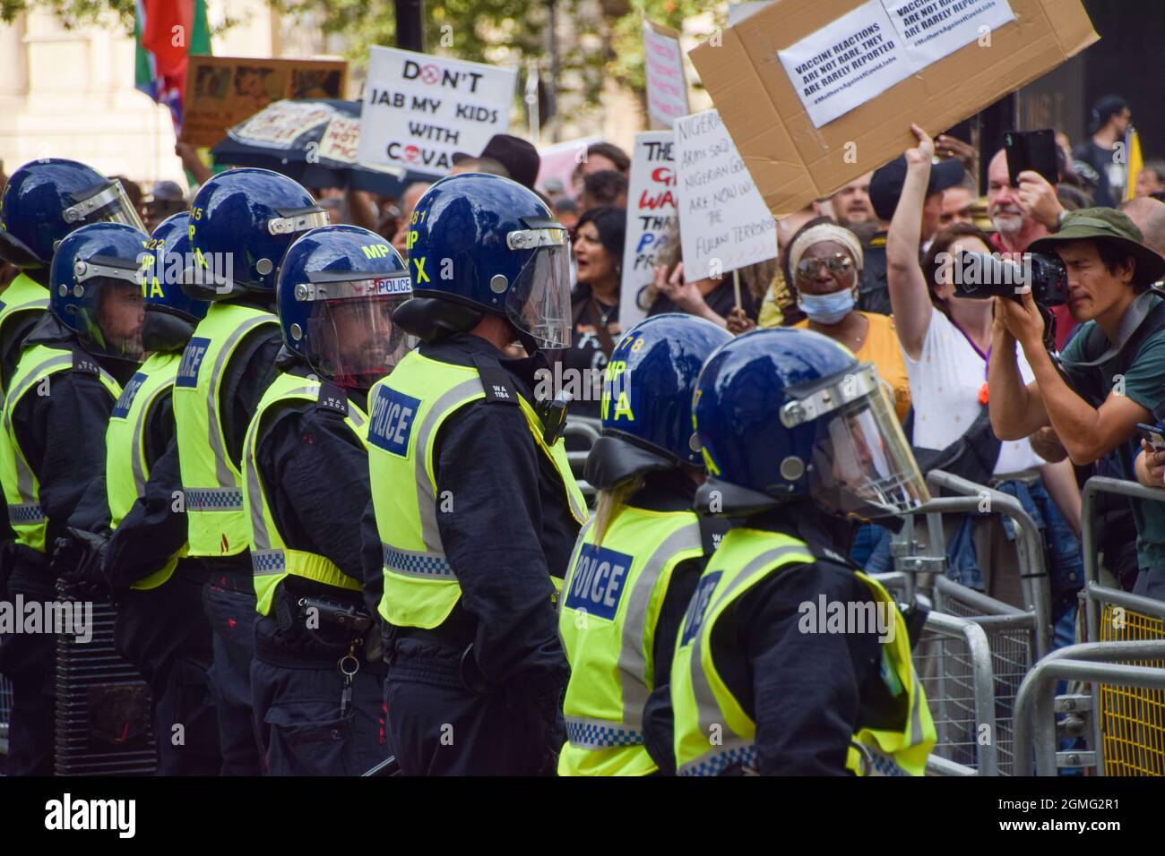 Police officers in riot gear observe protesters during the ...
