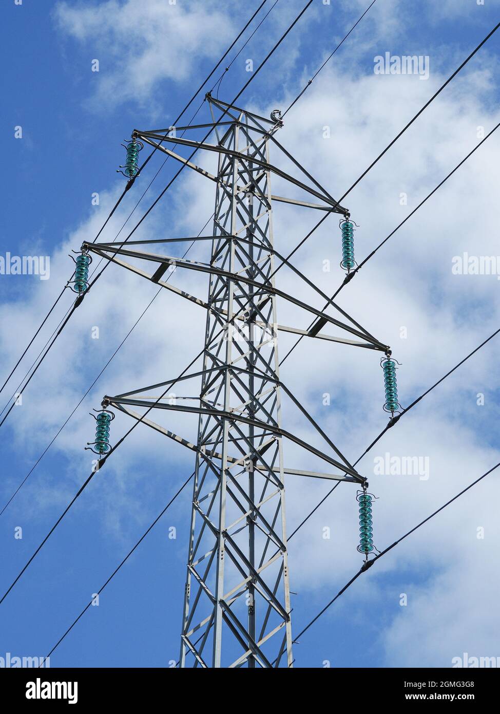 High voltage power lines pylons and electrical cables on a clear blue sky Stock Photo
