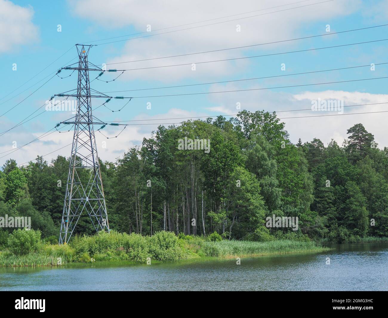 High voltage power lines pylons and electrical cables on a clear blue sky Stock Photo