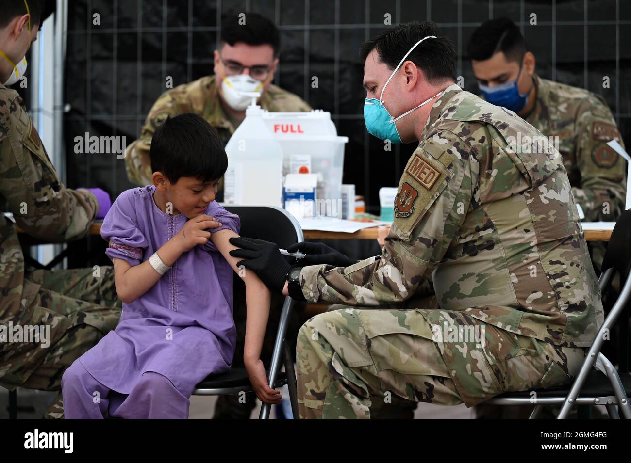 Ramstein-Miesenbach, Germany. 18th Sep, 2021. A U.S. Air Force airman administer Mumps, Measles and Rubella, and Chickenpox vaccines to an Afghan child evacuated from Kabul at Ramstein Air Base September 18, 2021 in Ramstein-Miesenbach, Germany. Ramstein is providing temporary lodging for evacuees from Afghanistan as part of Operation Allies Refuge. Credit: TSgt. Devin Nothstine/U.S. Air Force/Alamy Live News Stock Photo