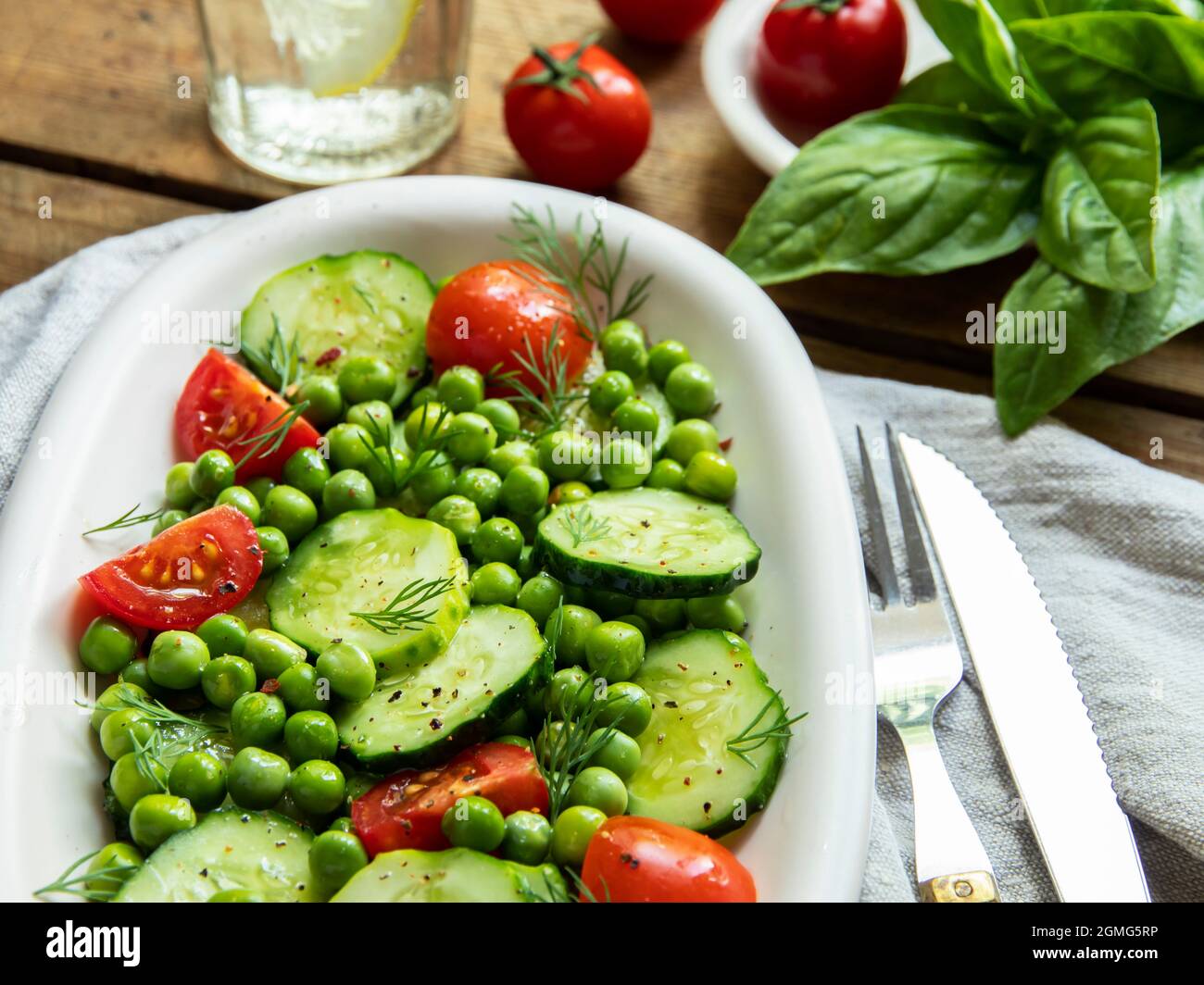Salad. Fresh vegetable salad with tomato, cucumber, basil, green peas. Stock Photo
