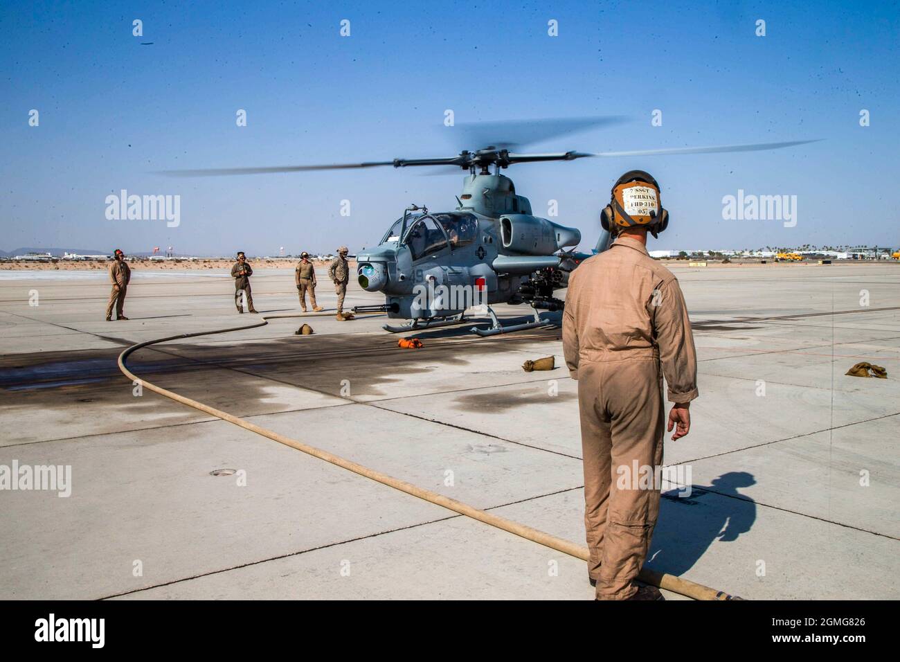 U.S. Marine Corps Staff Sgt. Joshua Perkins, a crew chief from Detroit, Mich., assigned to Marine Aviation Weapons and Tactics Squadron One (MAWTS-1), directs the landing of an AH-1Z Viper, during an air delivered ground refueling demonstration in support of Weapons and Tactics Instructor (WTI) course 1-22, at Marine Corps Air Station Yuma, Ariz., on Sept. 16, 2021. WTI is a seven-week training event hosted by MAWTS-1, providing standardized advanced tactical training and certification of unit instructor qualifications to support Marine aviation training and readiness, and assists in developin Stock Photo