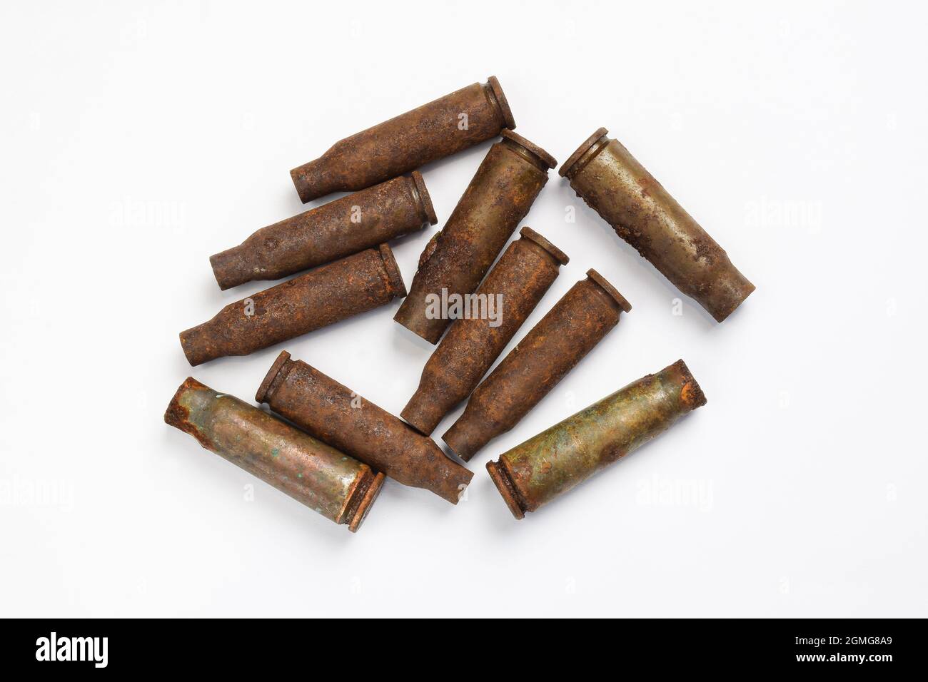 Ten old rusty military shells from a machine gun scattered on a white background Stock Photo