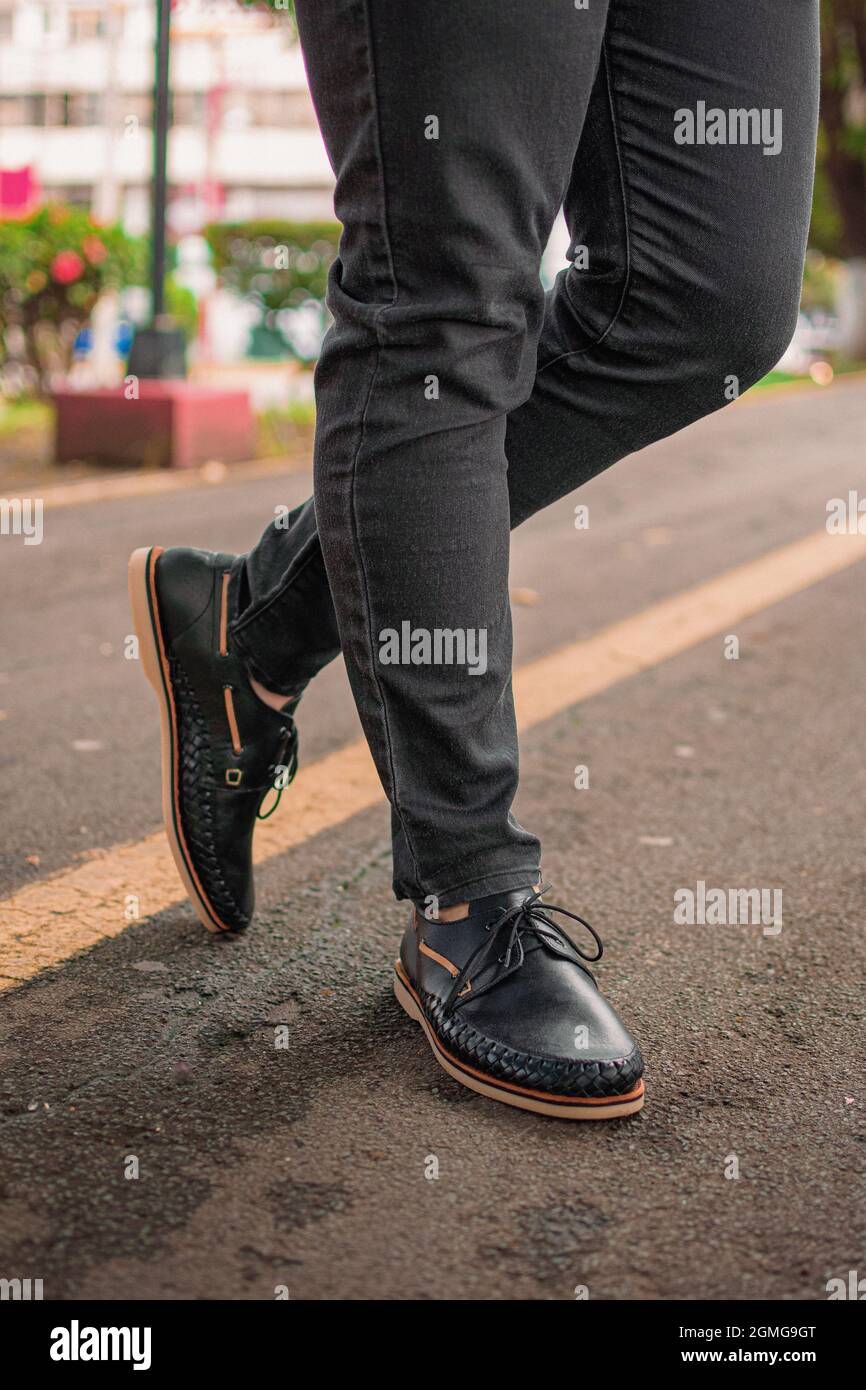 Vertical shot of a person wearing modern derby shoes with jeans and ...