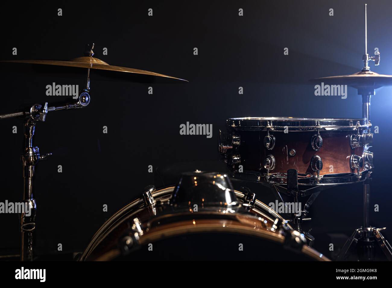 Drums, bass drum, hihat, cymbals on a dark background with beams from