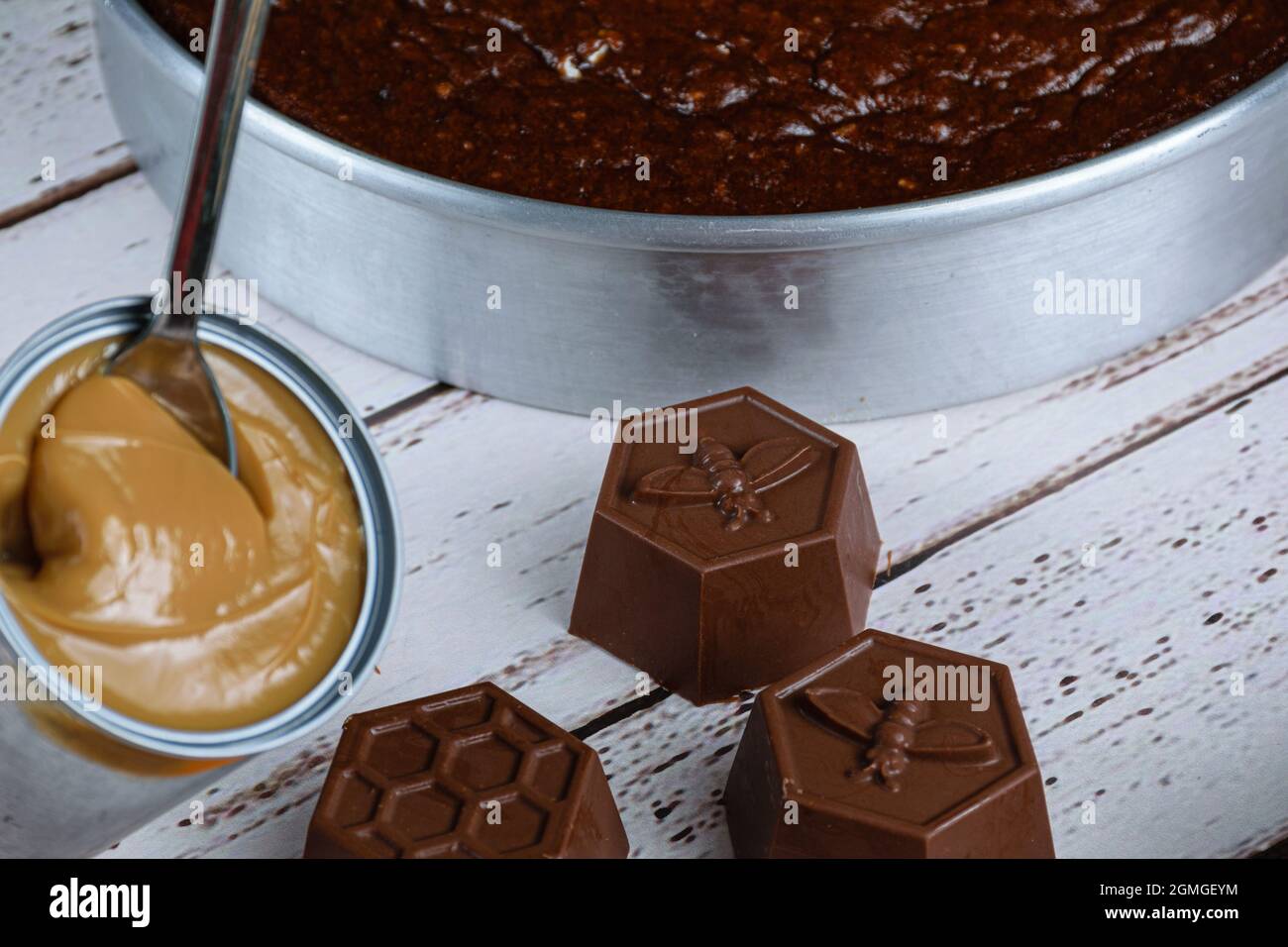 Small chocolate molds for making Brazilian honey cake, next to a can of dulce de leche. Stock Photo