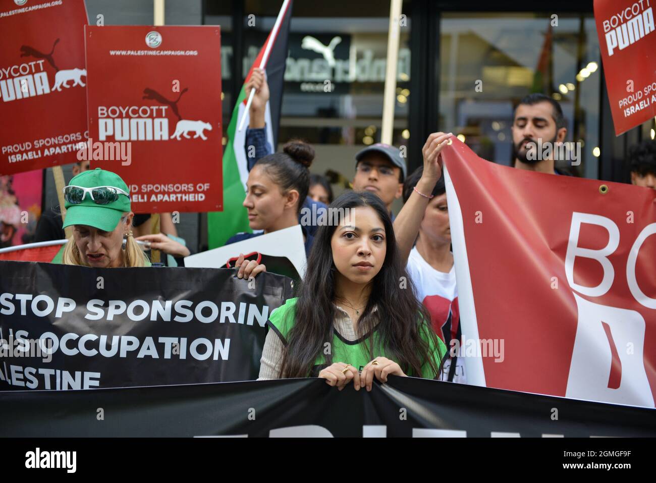 London, UK. 18th Sep, 2021. A protester standing behind a banner during the demonstration.Boycott Puma protest organised by Palestine Solidarity Campaign and FOA (Friends of Al Aqsa) at Puma flagship store on Carnaby Street, London. Activists demonstrated against Puma's sponsorship of the IFA (Israel Football Association). Credit: SOPA Images Limited/Alamy Live News Stock Photo