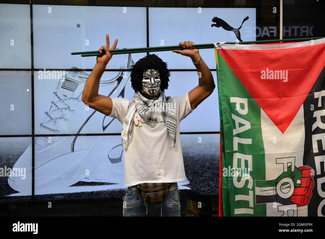 London, UK. 18th Sep, 2021. A protestor wearing a Guy Fawkes holding a Palestinian flag, during the demonstration.Boycott Puma protest organised by Palestine Solidarity Campaign and FOA (Friends of Al Aqsa) at Puma flagship store on Carnaby Street, London. Activists demonstrated against Puma's sponsorship of the IFA (Israel Football Association). Credit: SOPA Images Limited/Alamy Live News Stock Photo