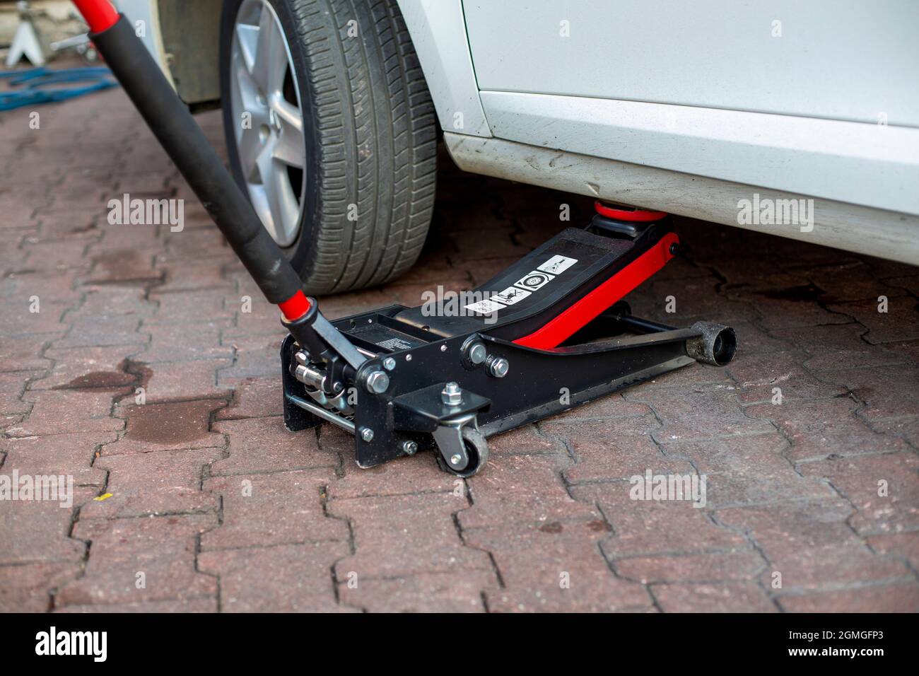 Tire change of a car. placing a jack under the car Stock Photo Alamy