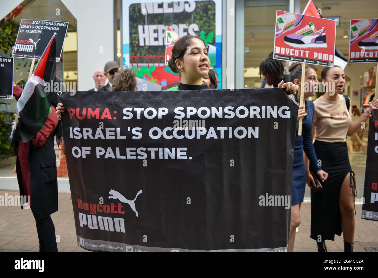 A protester standing behind a banner during the demonstration. Boycott Puma protest organised by Palestine Solidarity Campaign and FOA (Friends of Al Aqsa) at Puma flagship store on Carnaby Street, London. Stock Photo