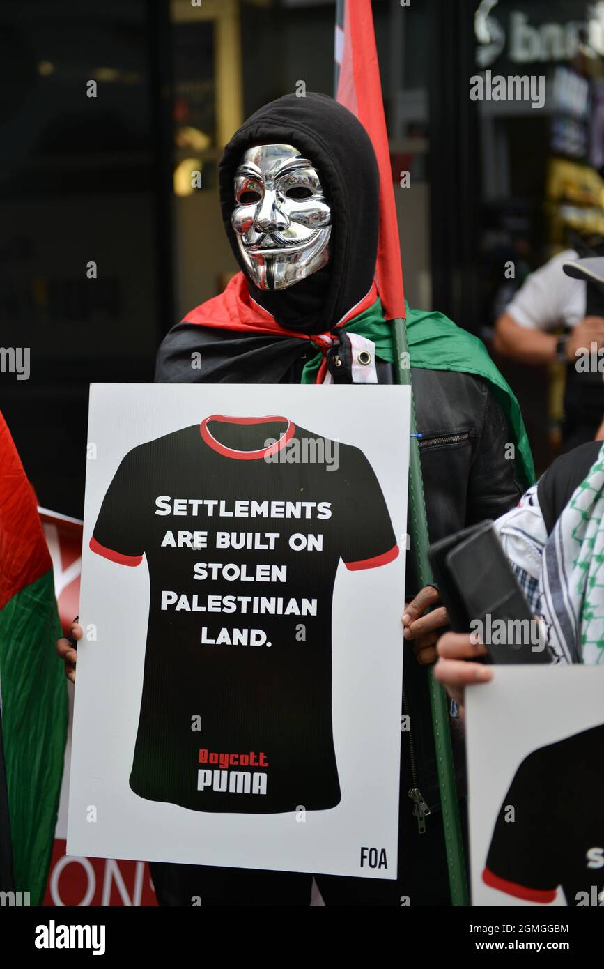 A protestor wearing a Guy Fawkes mask holding a placard, during the demonstration.Boycott Puma protest organised by Palestine Solidarity Campaign and FOA (Friends of Al Aqsa) at Puma flagship store on Carnaby Street, London. Activists demonstrated against Puma's sponsorship of the IFA (Israel Football Association). (Photo by Thomas Krych / SOPA Images/Sipa USA) Stock Photo