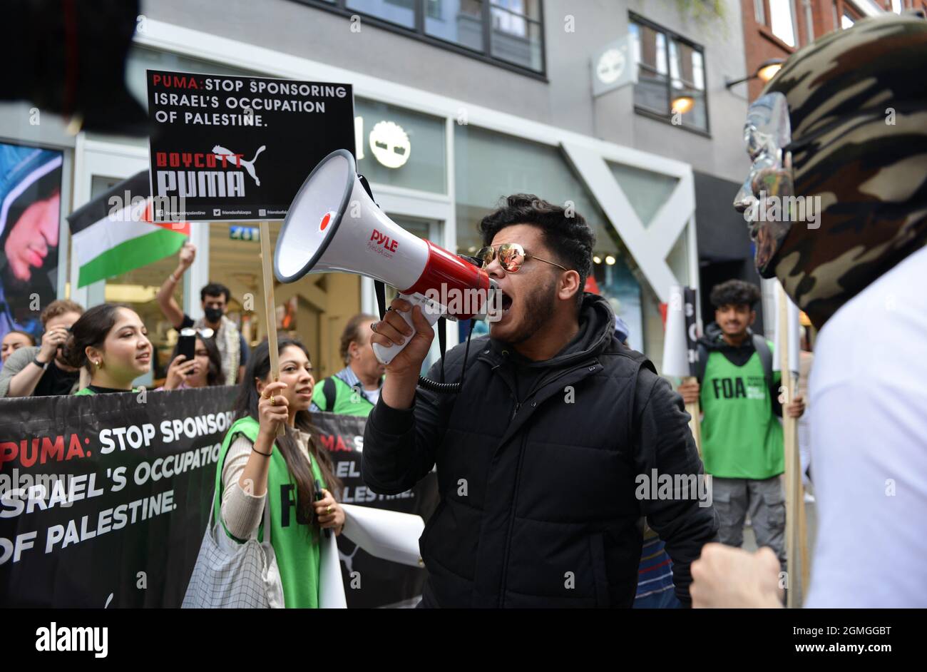 A protestor shouting through a megaphone during the demonstration.Boycott Puma protest organised by Palestine Solidarity Campaign and FOA (Friends of Al Aqsa) at Puma flagship store on Carnaby Street, London. Activists demonstrated against Puma's sponsorship of the IFA (Israel Football Association). (Photo by Thomas Krych / SOPA Images/Sipa USA) Stock Photo