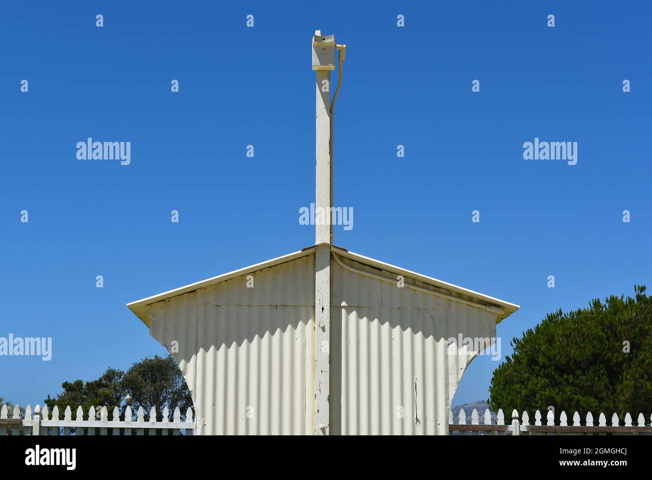 Shed Detail with fence blue sky and tree tops Stock Photo - Alamy