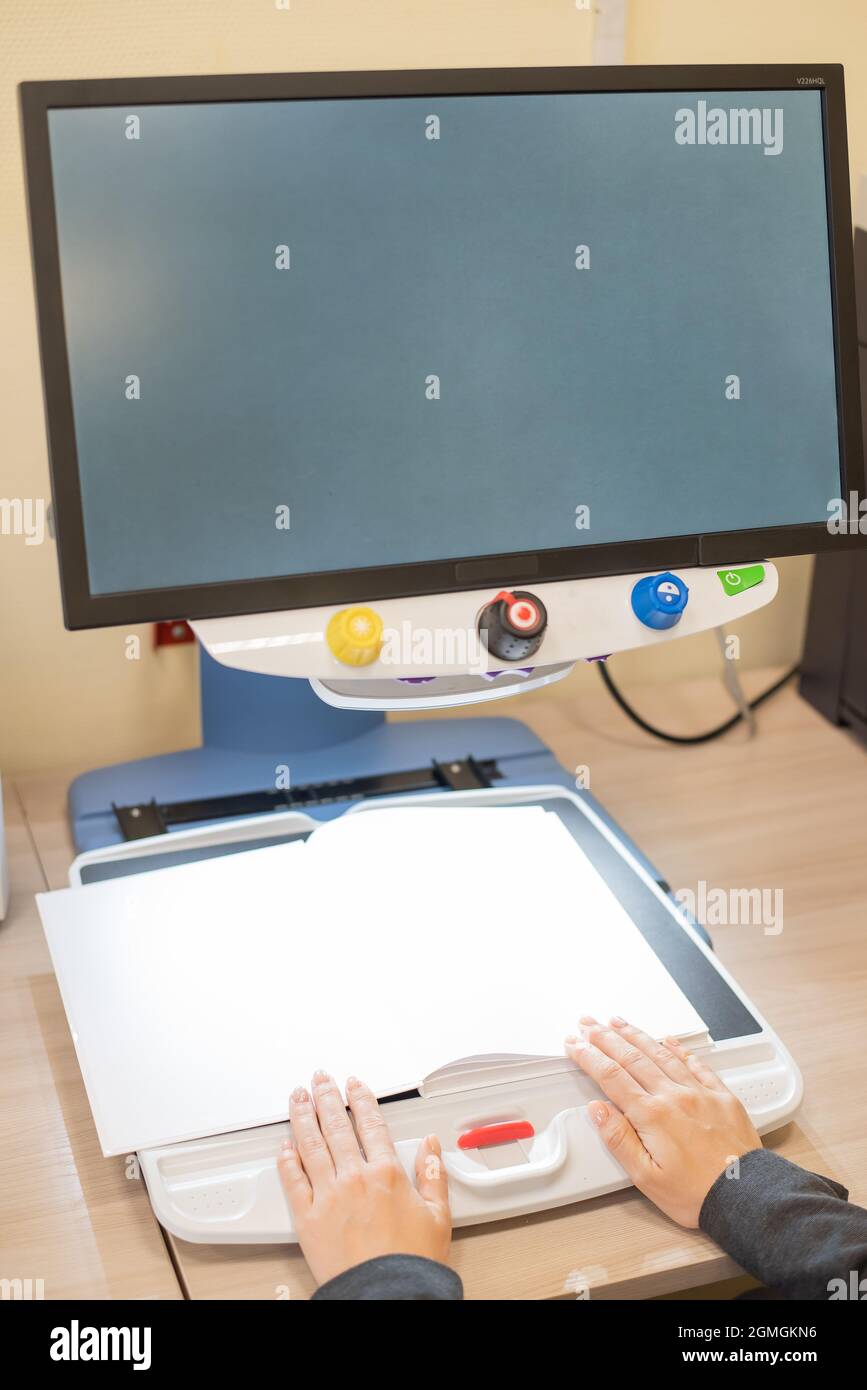 A visually impaired woman uses special reading equipment Stock Photo