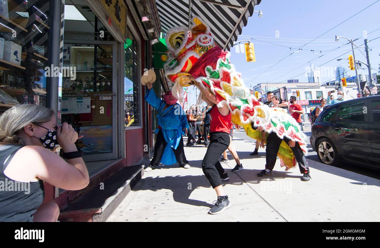 Toronto, Canada. 18th Sep, 2021. People perform a lion dance at the Chinatown in Toronto, Canada, on Sept. 18, 2021. A traditional lion dance parade was held here on Saturday to celebrate the upcoming Mid-Autumn Festival. Credit: Zou Zheng/Xinhua/Alamy Live News Stock Photo