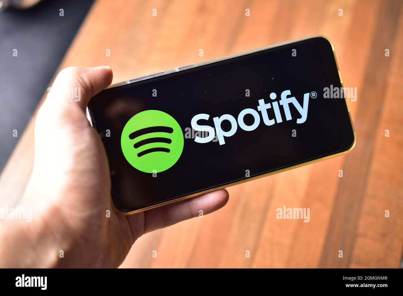 Delhi, India, October 23, 2019: hand holding smartphone and using Spotify app, music podcast application, Swedish application Stock Photo