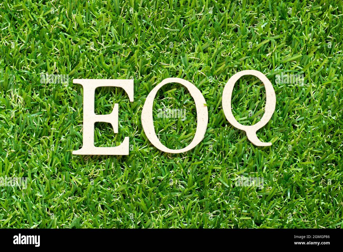 Alphabet letter in word EOQ (Abbreviation of Economic order quantity) on green grass background