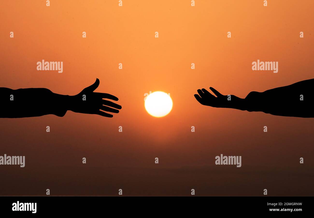 Human hand Asking help Concept. hands helping each other Against Sunset background. People helping, God salvation and Get Hired Concepts Stock Photo