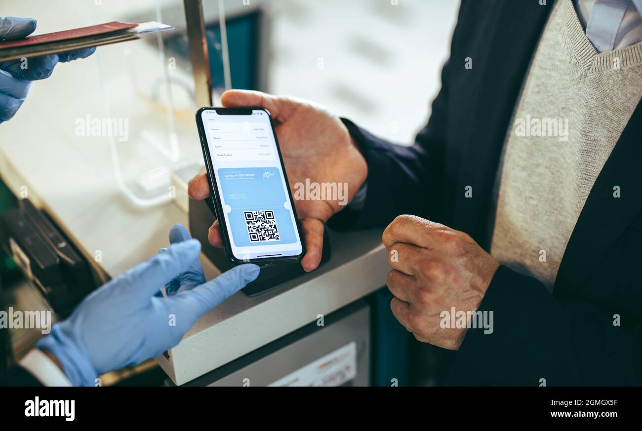 Passenger showing digital medical pass on his mobile to airline