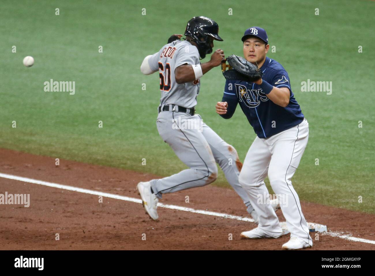 St. Petersburg, FL. USA;  Detroit Tigers center fielder Akil Baddoo (60) jumps back into first base and Tampa Bay Rays first baseman Ji-Man Choi (26) Stock Photo