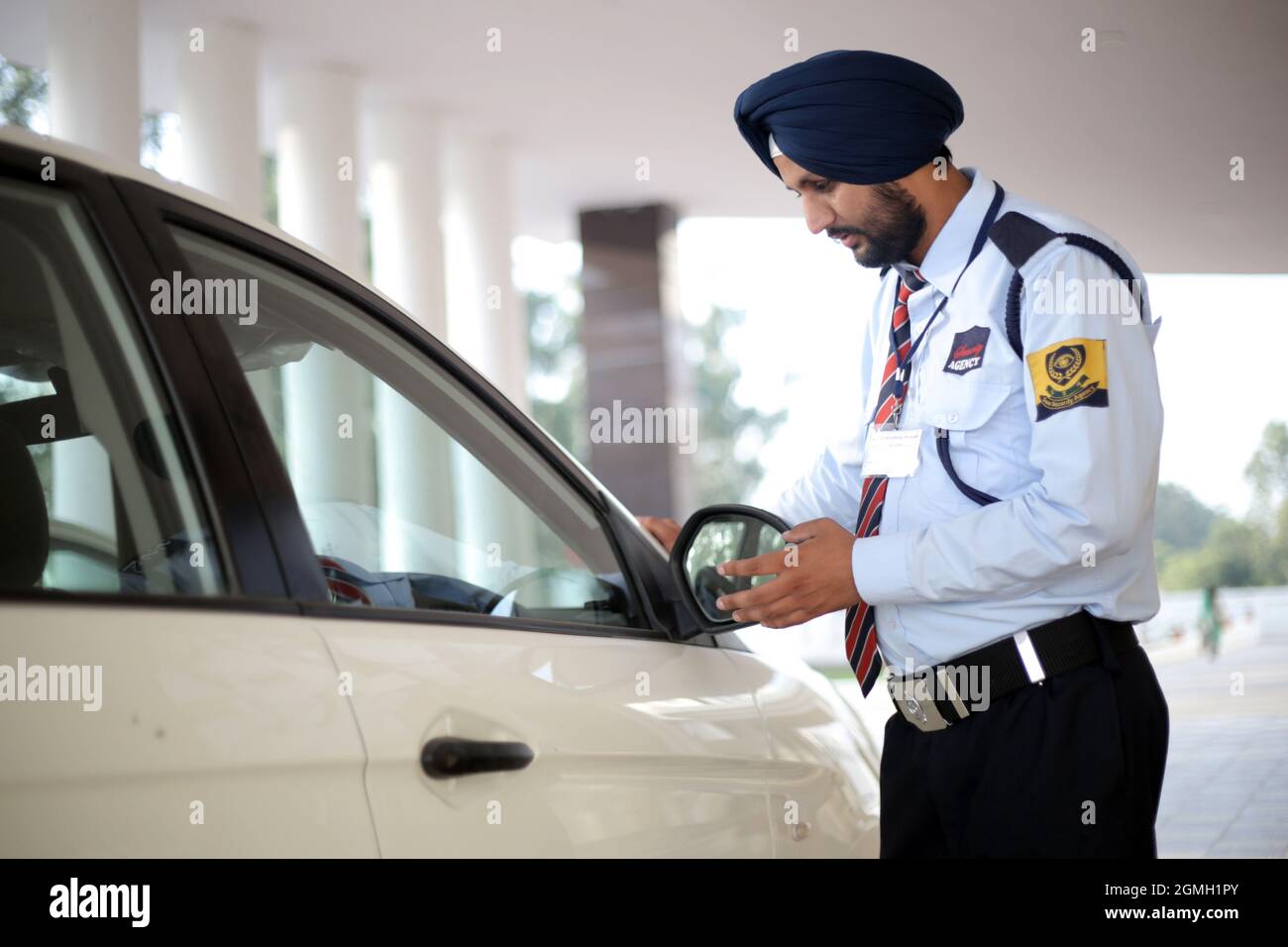 Sikh man Security Guard checking Car Stock Photo