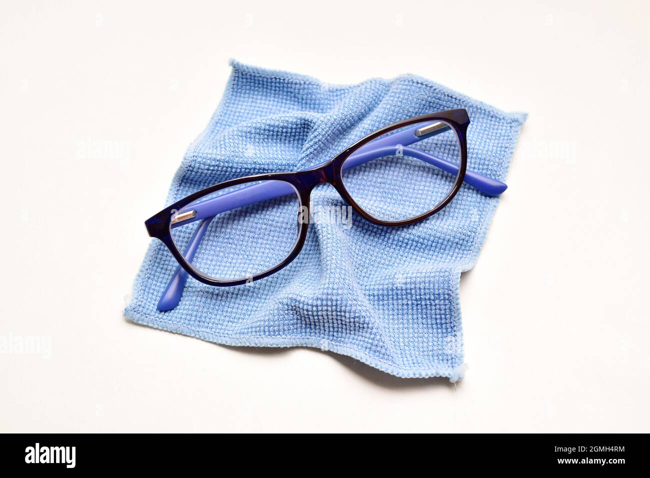 Eyesight Glasses with microfiber cloth over white background, eyewear  cleaning cloth Stock Photo