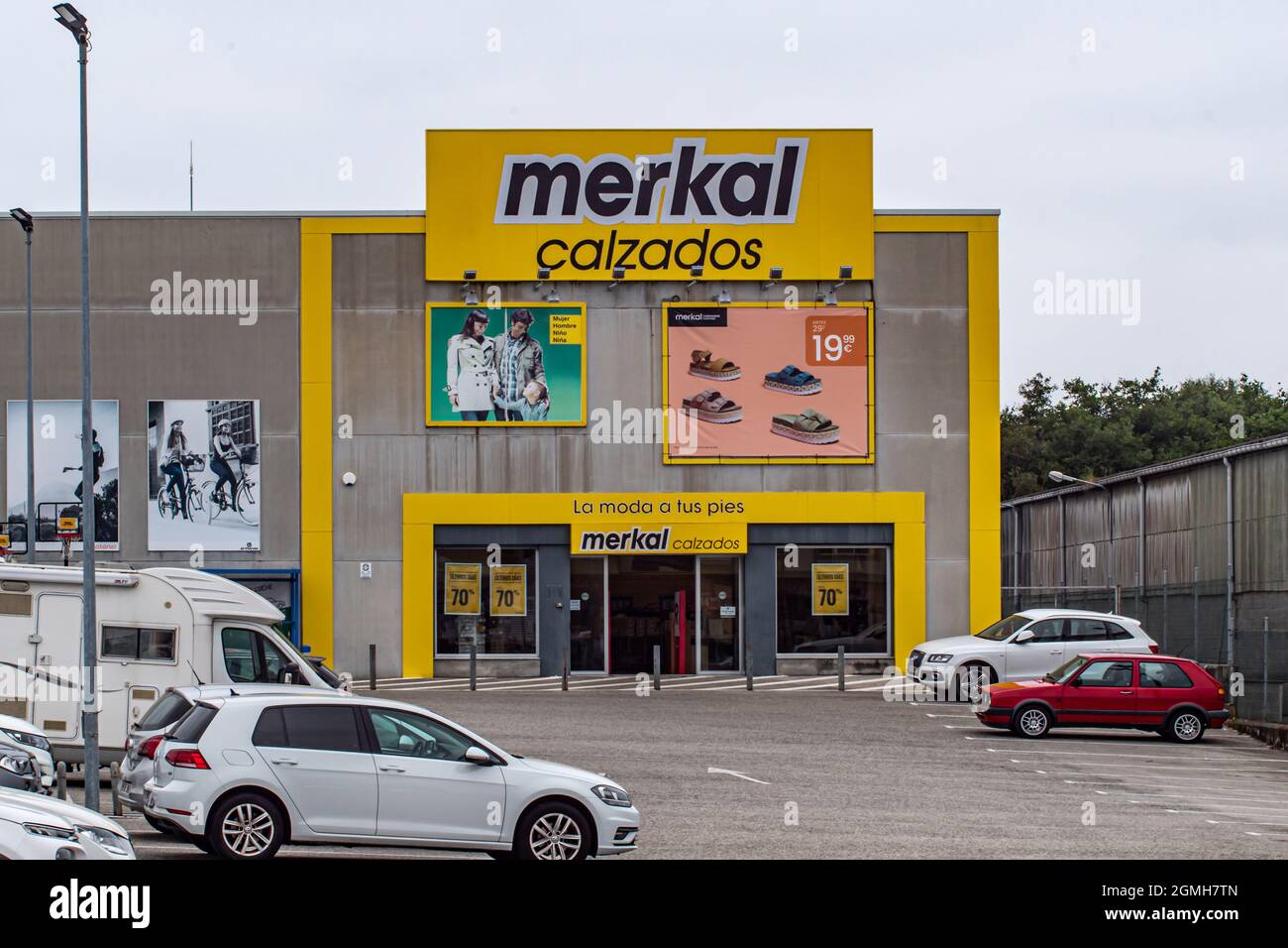 RIBADEO, SPAIN - Aug 31, 2021: A signage of MERKAL CALZADOS brand on yellow  billboard on facade of building in Ribadeo, Spain Stock Photo - Alamy