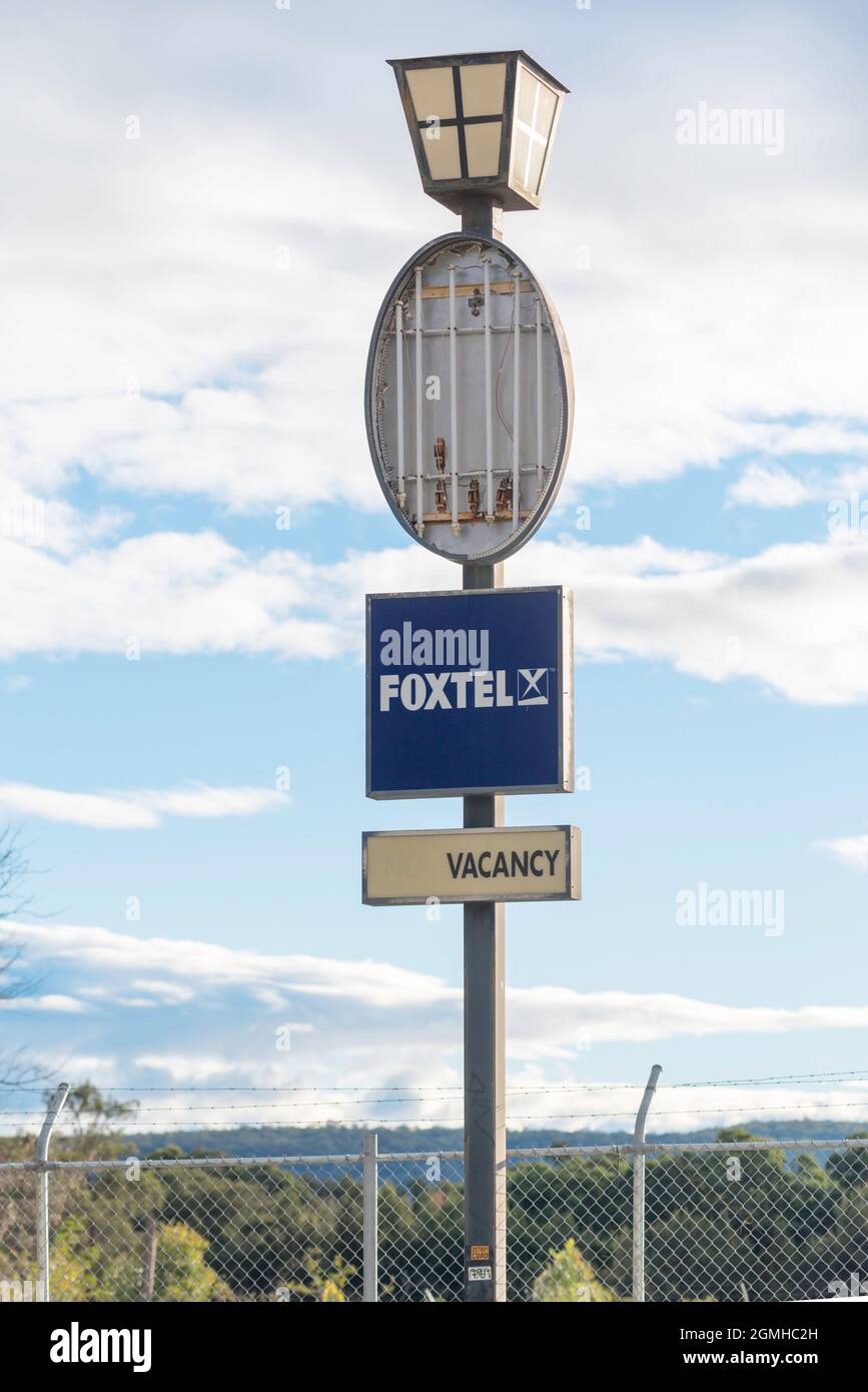 The motel is demolished and the land is vacant but the vacancy sign for the motel still stands and advertises Foxtel cable TV as a bonus Stock Photo