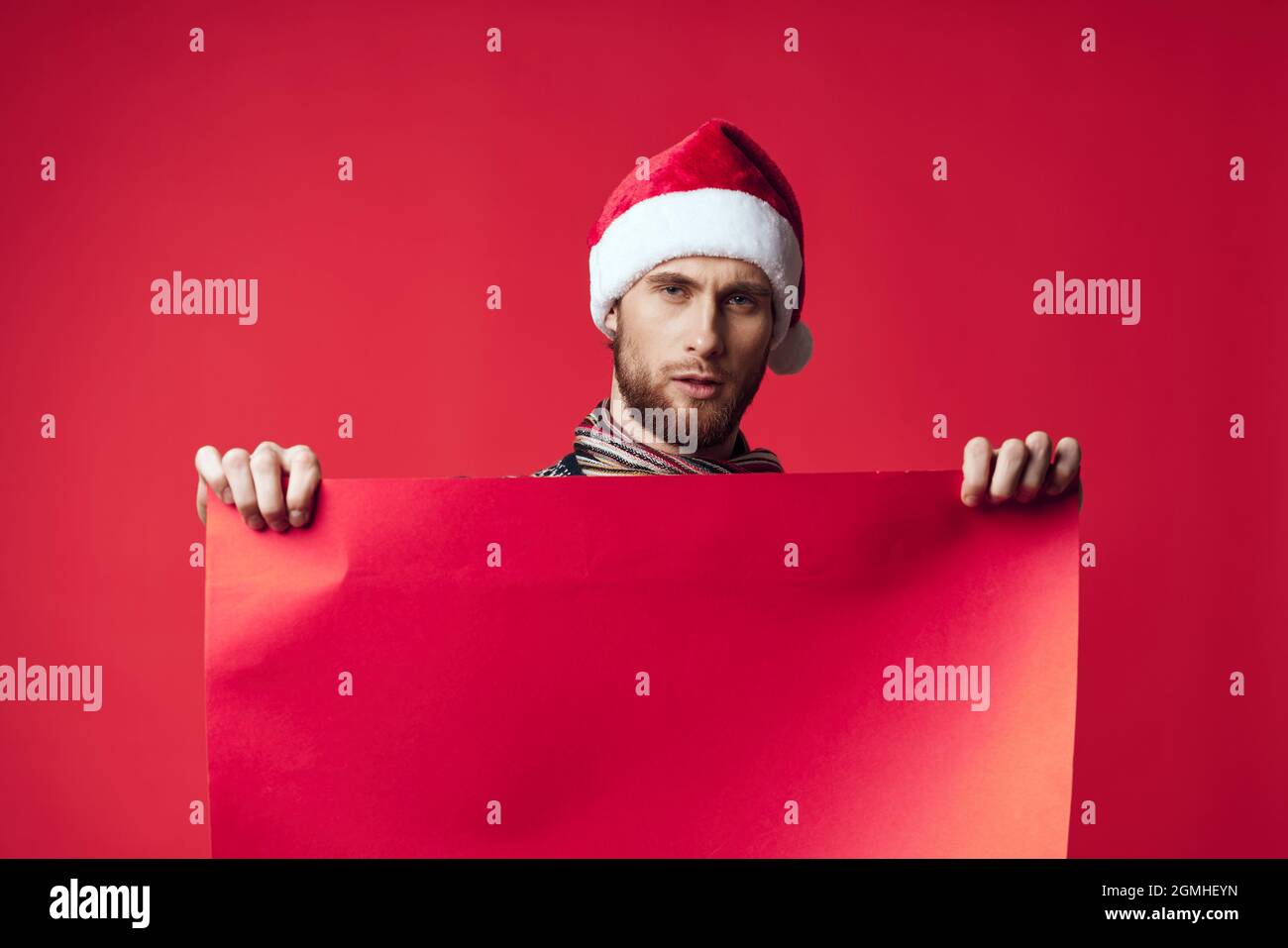 handsome man in a santa hat holding a banner holiday red background ...