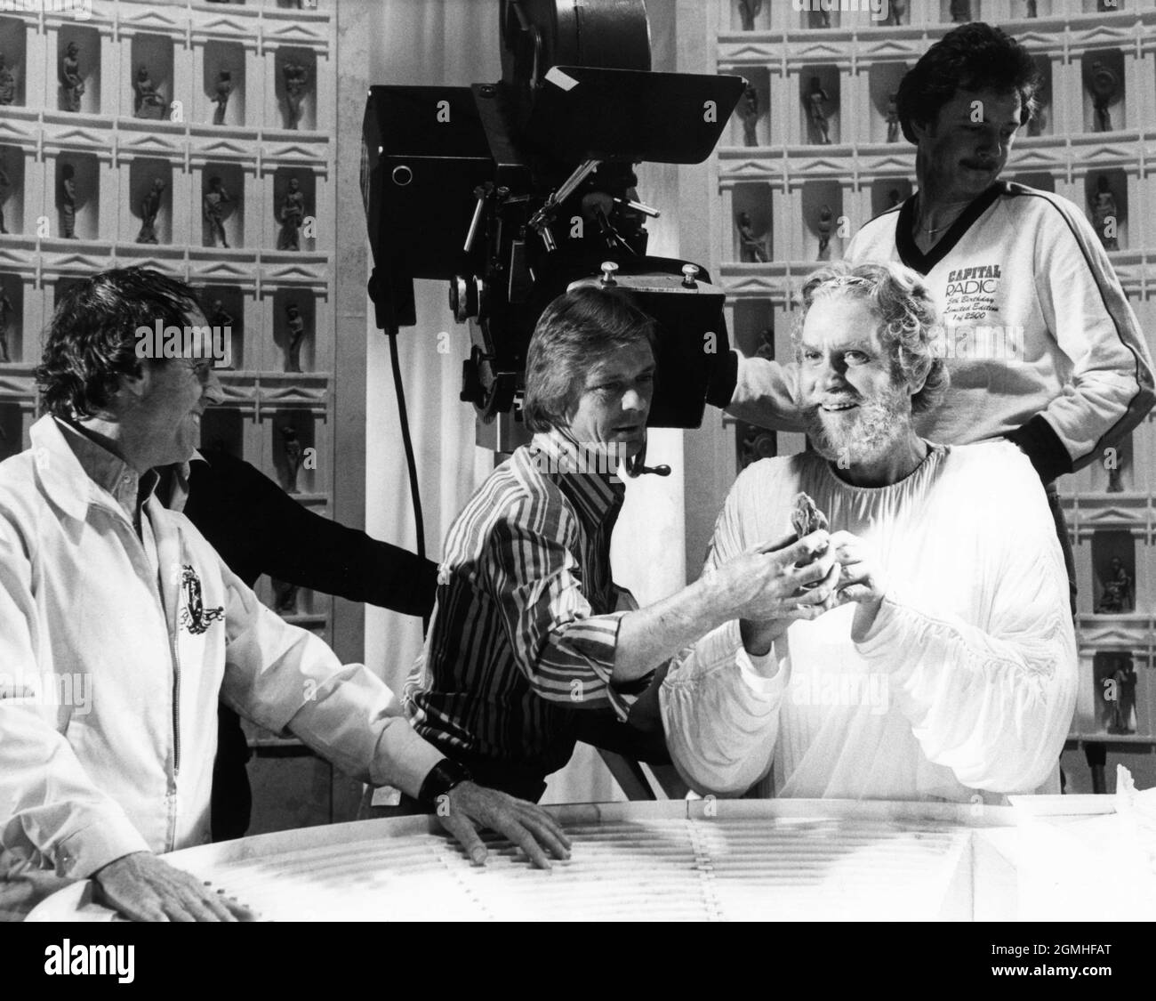 Director DESMOND DAVIS and LAURENCE OLIVIER as Zeus with Movie / Camera Crew on set candid during filming of CLASH OF THE TITANS 1981 director DESMOND DAVIS written by Beverley Cross costume design Emma Porteous creator of special visual effects (Dynamation) Ray Harryhausen music Laurence Rosenthal producers Charles H. Schneer and Ray Harryhausen Charles H. Schneer Productions / Peerford Ltd. / distribution Cinema International Corporation (CIC)  (UK) Metro Goldwyn Mayer (USA) Stock Photo