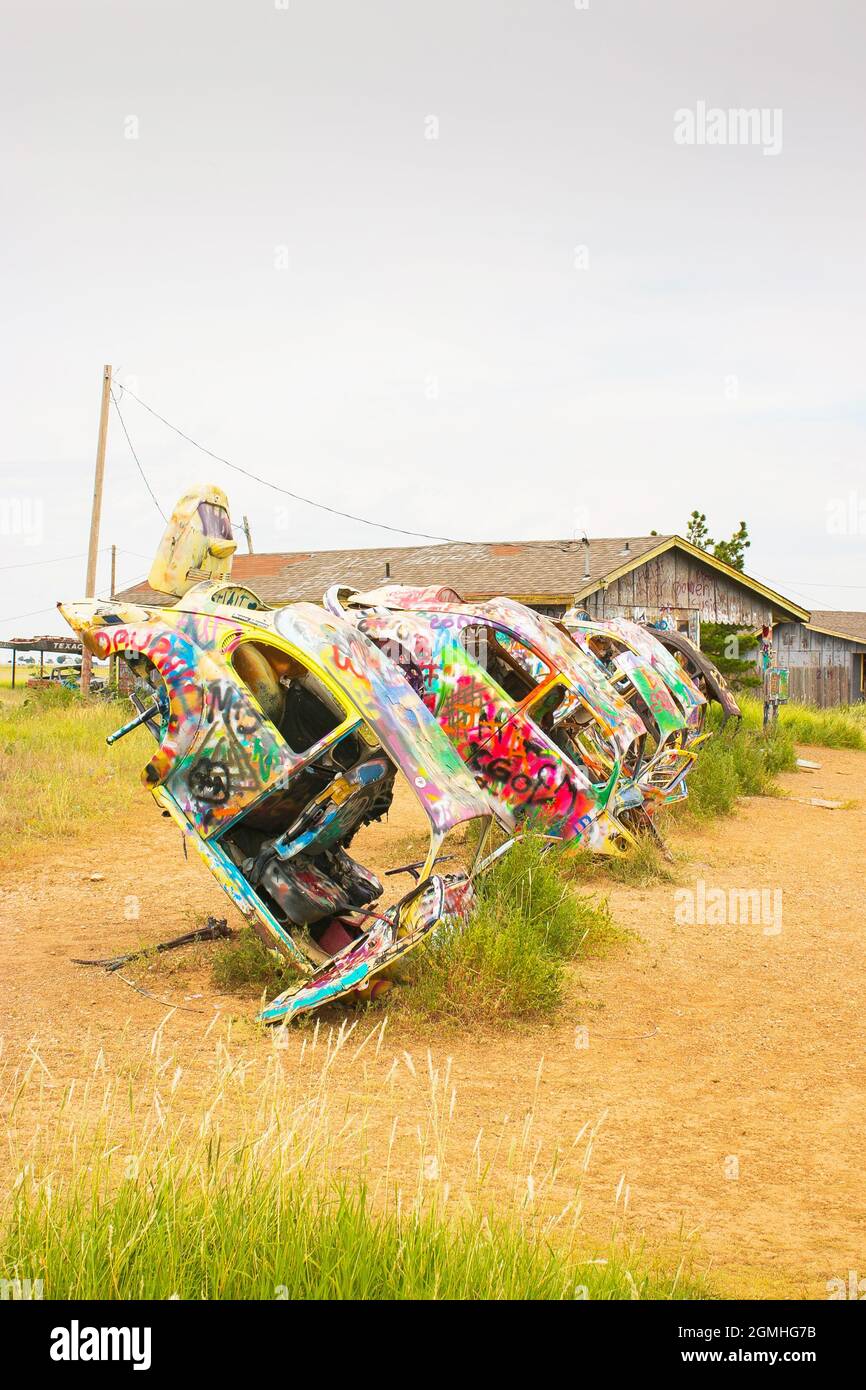 painted Volkswagen Beetles half buried at an angle at Slug Bug Ranch