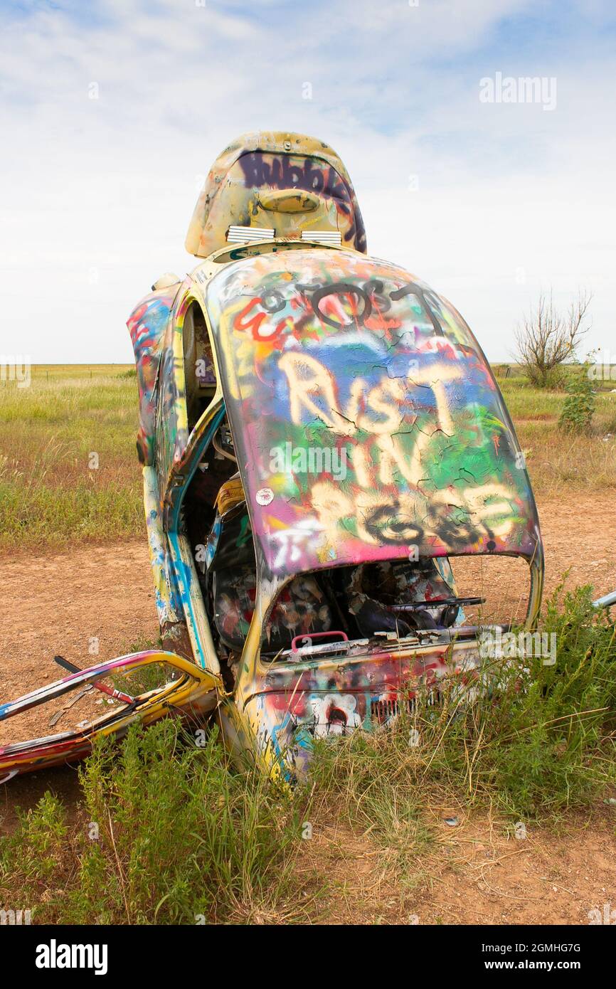 painted Volkswagen Beetles half buried at an angle at Slug Bug Ranch