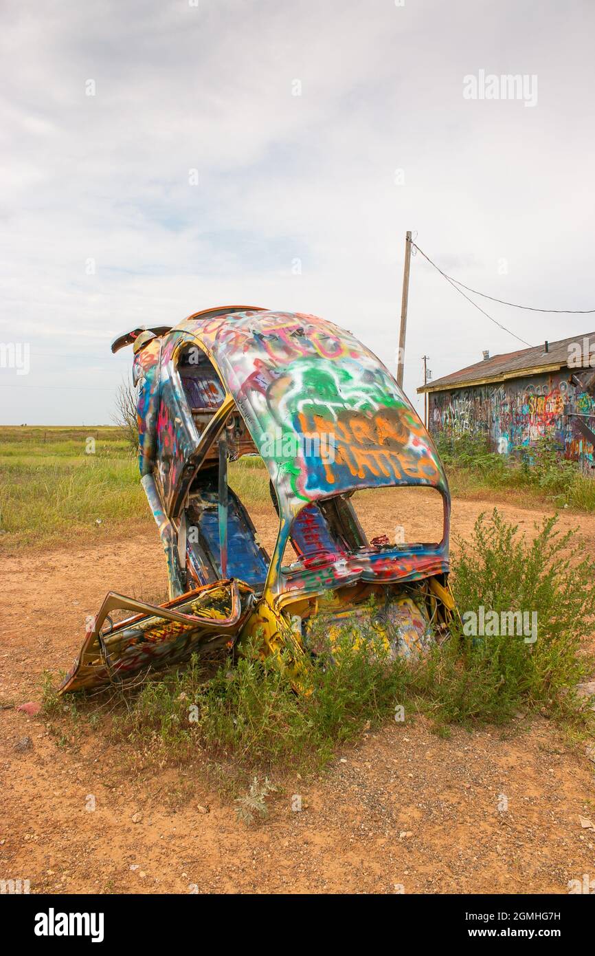 painted Volkswagen Beetles half buried at an angle at Slug Bug Ranch